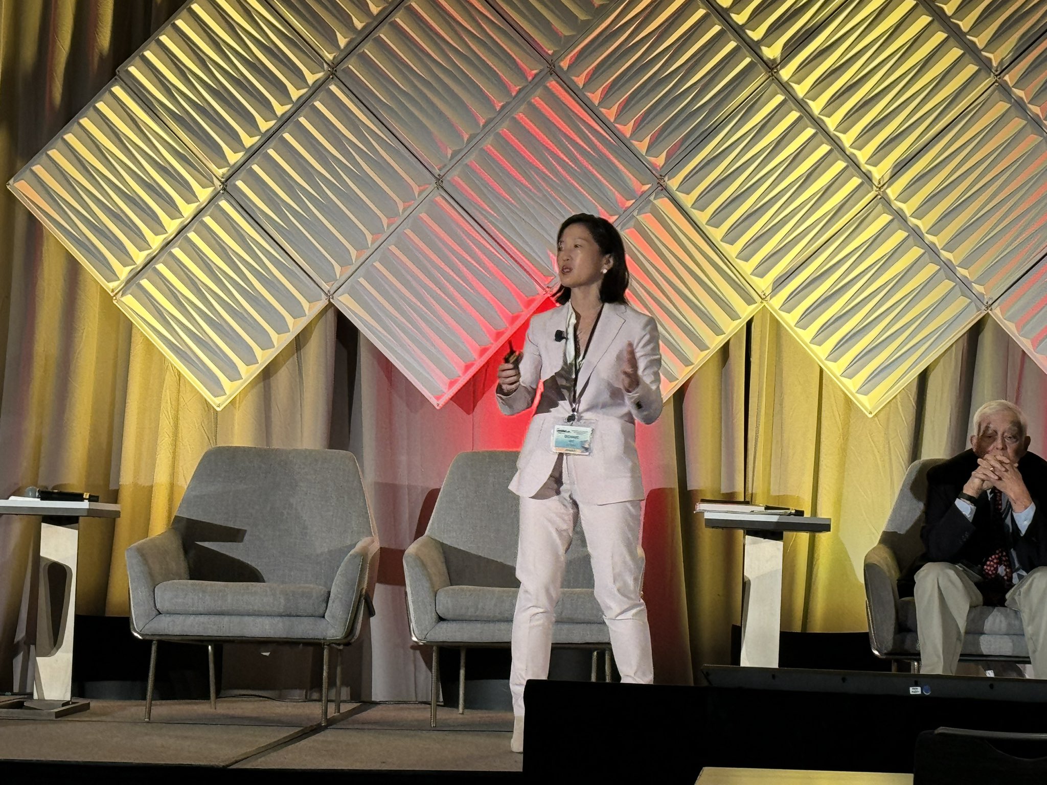 Bonnie Ky, an Asian woman wearing a white suit, talks at GCOS 2024