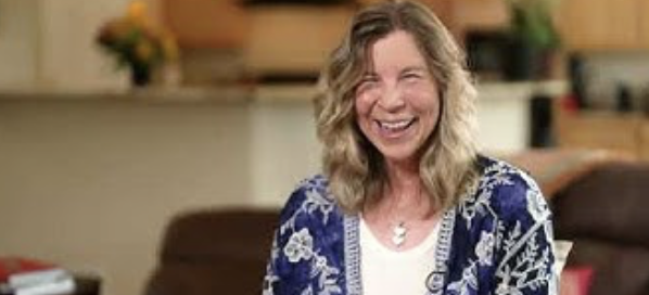 Susan S laughs against an office background