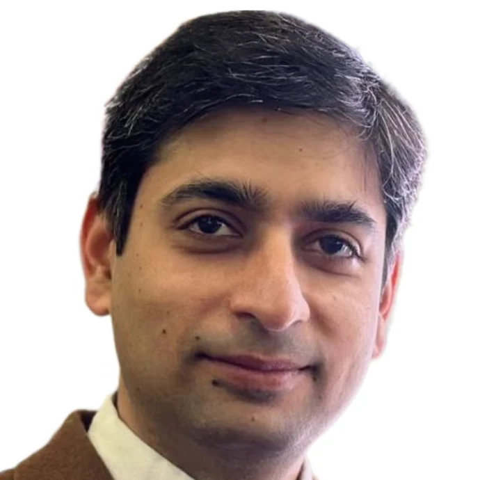 Sarju Ganatra MD FACC, a cardio-oncologist in Burlington, Massachusetts. He is an Indian man with dark hair speckled with grey. He wears a white collar and a brown suit
